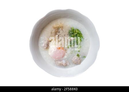 Congee di maiale con uova colazione cinese su sfondo bianco isolato, cibo di strada al mattino. (Tracciato di ritaglio). Foto Stock