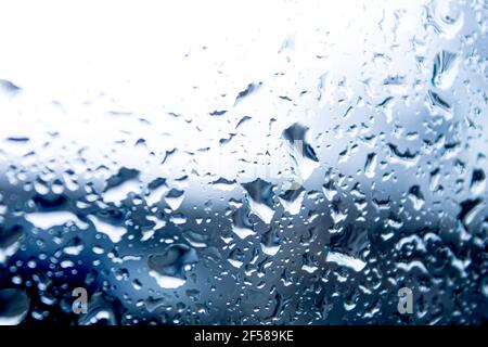 Gocce di pioggia sulla finestra. Appannamento ed evaporazione del vetro. Pioggia fuori dal finestrino. L'acqua scorre sul vetro. Foto Stock