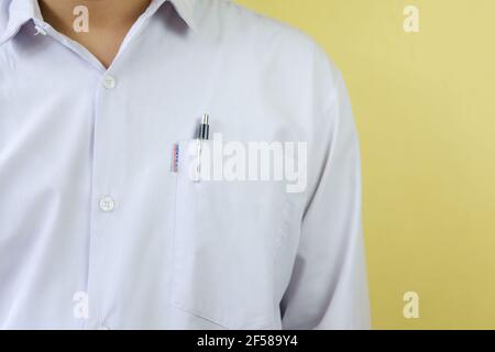 gioca il ruolo di uomo d'affari in camicia bianca e penna in tasca su sfondo bianco Foto Stock