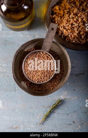 Bulgur Siyez in recipiente di misurazione in metallo su tavolo di legno blu. (Einkorn bulgur) Foto Stock