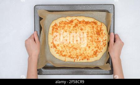 Pane piatto appena sfornato con mozzarella e primo piano sulla teglia da forno, appena dal forno, vista dall'alto. Foto Stock