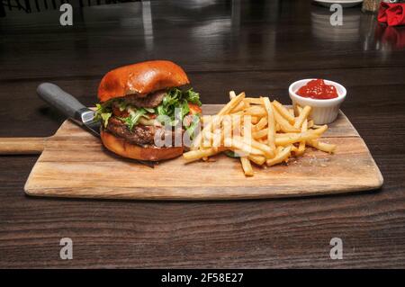 Delizioso cheeseburger con tutti i fissaggi su un panino Foto Stock