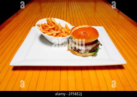 Delizioso cheeseburger con tutti i fissaggi su un panino Foto Stock