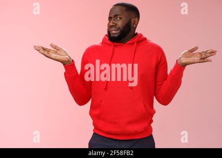 L'uomo afro-americano fringe shake head ignaro accigliato grimacing avversione dissimile shrugging mani alzate lateralmente non hanno idea, in piedi insoddisfatto Foto Stock