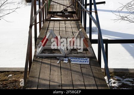 Proibire la segnaletica e la scacchiera in russo "il passaggio è vietato" all'ingresso di uno stretto ponte pedonale Foto Stock