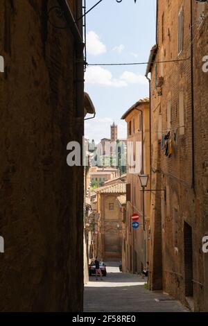 Vicolo stretto con edifici antichi nella città medievale di Siena, Toscana Foto Stock