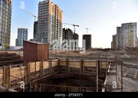 Vista sul grande cantiere con gru a torre ed edifici. Costruzione di un collettore fognario. Acque reflue urbane sotterranee. Drenaggio-commu Foto Stock