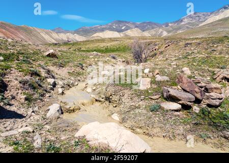 Piccolo ruscello con acqua fangosa nelle alture Foto Stock