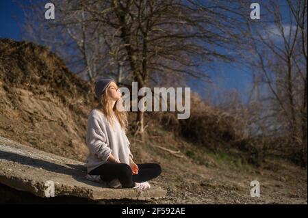 Pratica della meditazione e dell'interazione con la natura. Ragazza vicino al fiume Foto Stock