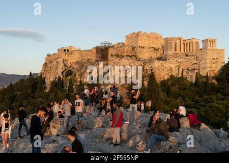 Atene, Grecia - Maggio 07 2020: I turisti godono del tramonto sull'Acropoli e sul tempio del Partenone dal Monte Areopago ad Atene. Foto Stock