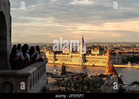 Budapest, Ungheria - Maggio 27 2019: I turisti si godono il tramonto sulla città vecchia di Budapest e il famoso palazzo del Parlamento sul fiume Danubio Foto Stock