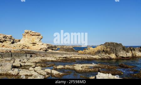 Paesaggio di rocce ruvide sulla spiaggia di Ognina, Italia Foto Stock