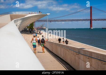 Museo d'Arte, architettura e tecnologia con il ponte aprile 25 sullo sfondo che attraversa il fiume Tago, Belem, Lisbona, Portogallo Foto Stock