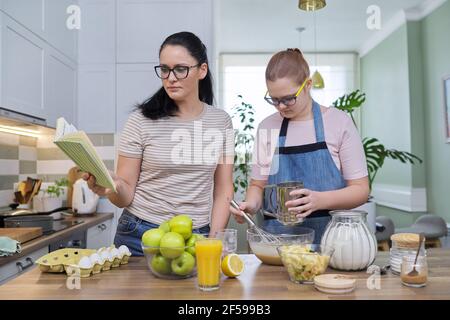 Mamma e figlia presea che cucinano insieme a casa Foto Stock