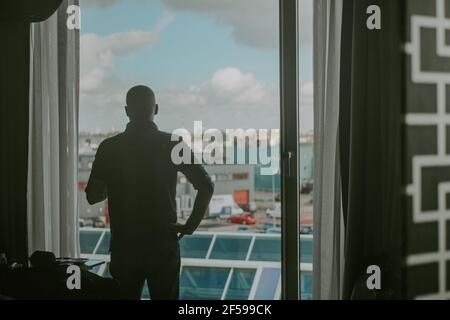 AMSTERDAM, PAESI BASSI - 17 marzo 2021: Ripresa orizzontale di un giovane maschio dall'angolo posteriore, guardando il paesaggio urbano di Amsterdam, Paesi Bassi Foto Stock