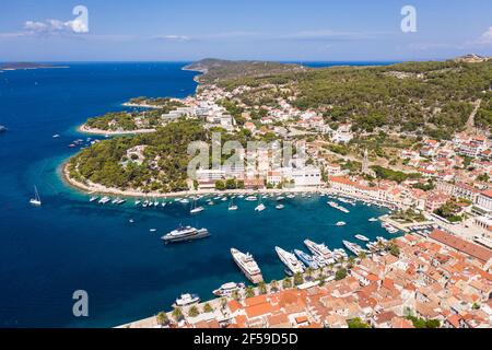 Splendida vista aerea della famosa isola di Hvar e della città vecchia Città con il suo porto di yacht di lusso in Croazia su un giorno estivo soleggiato Foto Stock