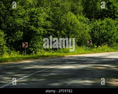 Autostrade asfaltate strada circondata da foresta, segnaletica stradale, trasporto terrestre e sfondo, sfondo Foto Stock