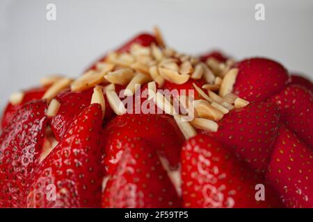 Torta di fragole con mandorle, cioccolato fondente e panna montata alla vaniglia. Primo piano dell'immagine. Foto Stock
