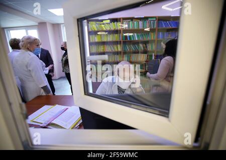 KHARKIV, UCRAINA - 25 MARZO 2021 - gli operatori sanitari sono visti attraverso la finestra presso la reception del Kharkiv Policlinics N20 durante il COVID-1 Foto Stock