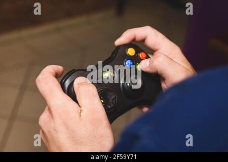 Bielorussia, regione di Minsk - 27 agosto 2017: Le mani del ragazzo stanno tenendo un joystick xbox e giocando una console, primo piano. Foto Stock