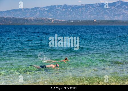 Due persone nuotano in acqua trasparente. Snorkeling, mare, vacanze estive, viaggi. Foto Stock