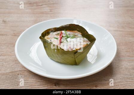 pesce al vapore con pasta di curry in vassoio di foglie di banana su piastra Foto Stock