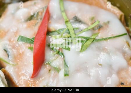 pesce al vapore con pasta di curry in vassoio di foglie di banana su piastra Foto Stock