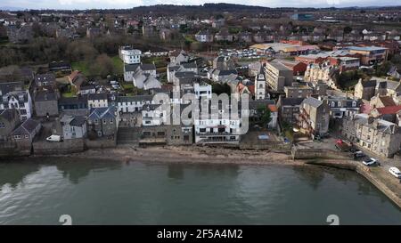 South Queensferry, Scozia, Regno Unito. 25 Marzo 2021. NELLA FOTO: South Queensferry sulla riva del Firth of Forth con (in basso a destra) Willie Rennie MSP con Daphne che è la figlia di Rebecca Bell, candidato. Willie Rennie MSP - leader del Partito Liberale democratico Scozzese (Scottish Lib Dems) si è Unito a Rebecca Bell, candidato di Edimburgo Northern e Leith, e a sua figlia Daphne. Legge la figlia di Rebecca un libro su una sedia gigante da spiaggia con la vista del Forth Bridge dietro come parte del loro percorso di campagna elettorale Holyrood per il 6 maggio. Credit: Colin Fisher/Alamy Live News Foto Stock