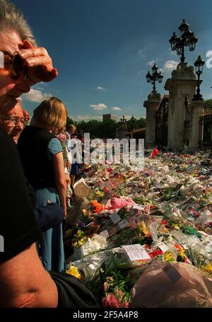 Principessa Diana morte 31 agosto 1997Mornatori che posano e osservano fiori Lasciato fuori Buckingham Palace in memoria della principessa Diana Who È stato ucciso in un incidente d'auto a Parigi Foto Stock