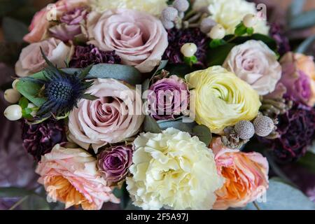 Bel bouquet di fiori d'annata. Decorazione floreale. Rose, carnationon e foglie su sfondo scuro. Sfondo floreale. Foto Stock