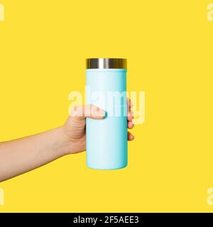 La tazza da viaggio per le maniglie è isolata su sfondo bianco. Tazza termica o bicchiere a mano femmina. Foto Stock
