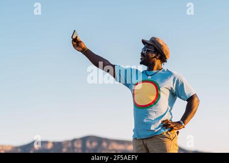 sorridente afroamericano con telefono cellulare che scattano una foto Foto Stock