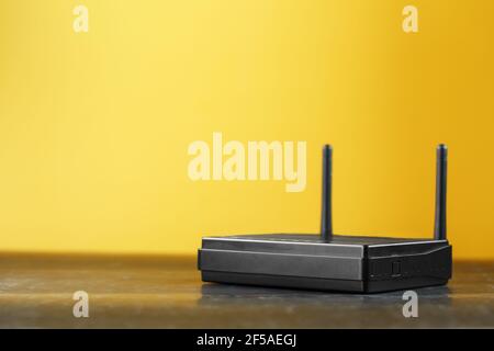 Tecnologia LAN wireless del router con dispositivi basati sugli standard IEEE 802.11 su sfondo giallo, vista dall'alto spazio libero. Isolare Foto Stock