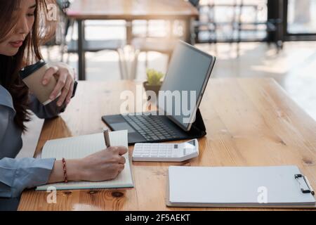 Contabile aziendale in ufficio facendo contabilità lavoro con il caffè al mattino. Foto Stock