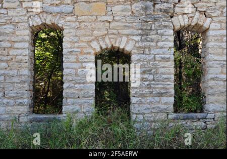 La porta in pietra ad arco e le finestre nelle rovine di un ex negozio generale sulla vecchia Route 66 a Plano, Missouri. Foto Stock