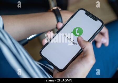 CHIANG mai, THAILANDIA - 1 FEBBRAIO 2032 : uomo che tiene iPhone con il logo Whatsapp sullo schermo del cellulare. Foto Stock