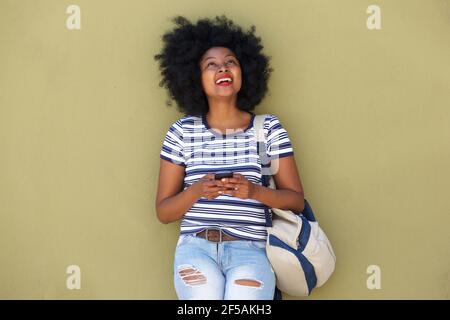 Ritratto di donna felice con smartphone che invia testo con borsa Foto Stock