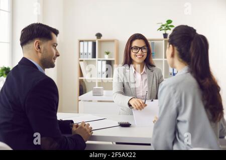 Amichevole lavoratore bancario che dà penna per firmare il contratto promettente bene trattare con il cliente Foto Stock