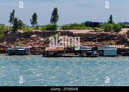 Vista dal Mekong alla zona costiera. Questo è fiancheggiato da tipici edifici in stilt di ferro corrugato. Foto Stock