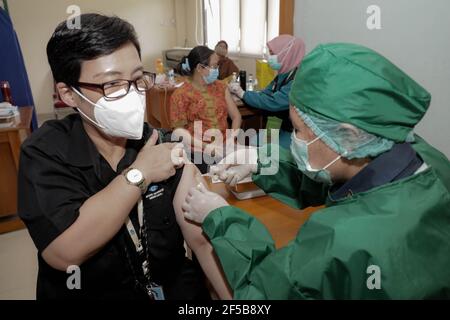 Un operatore sanitario inietta una dose di vaccino Sinovac COVID-19 a un lavoratore durante una campagna di vaccinazione di massa per i lavoratori del settore pubblico presso l'Ufficio dell'Agenzia di informazione geospaziale di Bogor.Indonesia è attualmente nella seconda fase della vaccinazione di massa Covid-19. In questa seconda fase, il governo indonesiano si rivolge a 38.5 milioni di persone, tra cui 16.9 milioni di lavoratori nei settori pubblici e 21.6 milioni di anziani, nonché ai lavoratori dell'ospitalità, dei trasporti, del turismo e dei mass media. Foto Stock