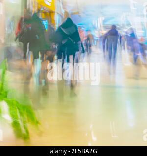 Gente offuscata che si precipita nel centro commerciale. Colorato luminoso sfondo astratto Foto Stock
