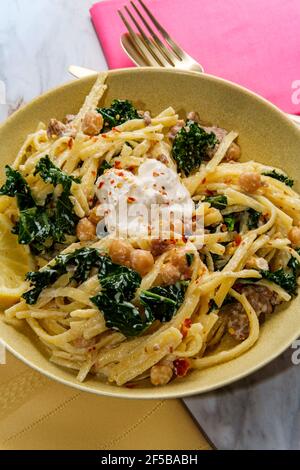 Linguine pasta con salsiccia italiana ceci e kale in un salsa cremosa di ricotta Foto Stock