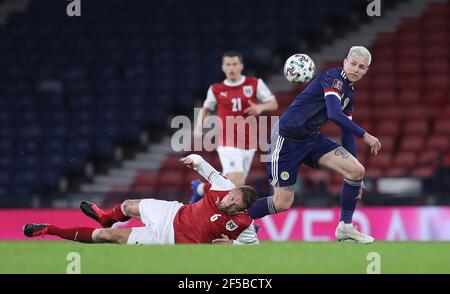 Stefan Ilsanker (a sinistra) e Lyndon Dykes (Scozia) si battono per la palla durante la partita di qualificazione della Coppa del mondo FIFA 2022 all'Hampden Park, Glasgow. Data immagine: Giovedì 25 marzo 2021. Foto Stock