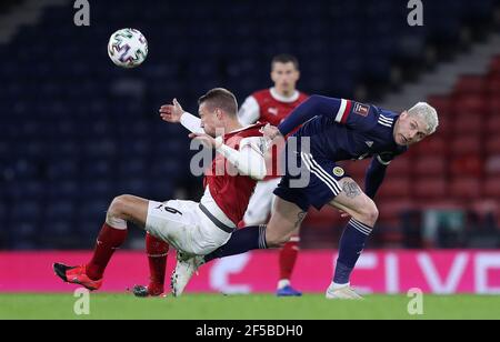 Stefan Ilsanker (a sinistra) e Lyndon Dykes (Scozia) si battono per la palla durante la partita di qualificazione della Coppa del mondo FIFA 2022 all'Hampden Park, Glasgow. Data immagine: Giovedì 25 marzo 2021. Foto Stock