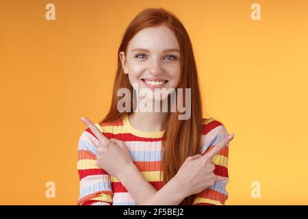 Rilassato spensierato sicuro giovane ragazza utile rossa mostrandoti le scelte puntando i bracci incrociati verso sinistra verso destra diverse direzioni sono presenti diverse varianti di prelievo Foto Stock