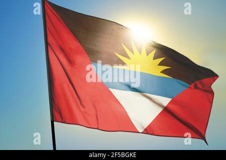 Antigua e Barbuda bandiera che sventolano sul vento davanti di sole Foto Stock