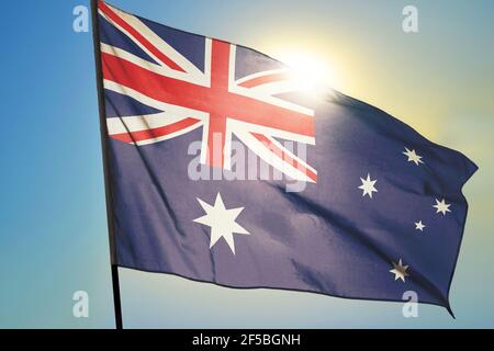 Bandiera australiana che sventola sul vento davanti al sole Foto Stock