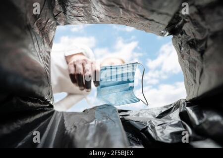 Lancio medico Corona Virus maschera viso in Bin Foto Stock