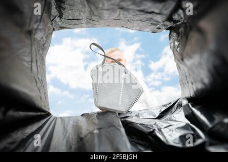 Lancio medico Corona Virus maschera viso in Bin Foto Stock