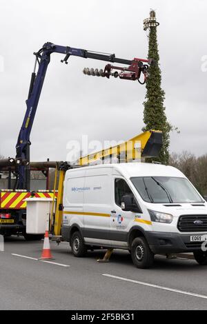 Kelly Engineer rimuovere il vecchio palo del telegrafo utilizzando il braccio della gru a bordo strada Foto Stock